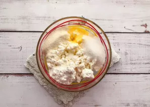 Mix cottage cheese, egg, vanilla sugar and regular sugar in a deep bowl.