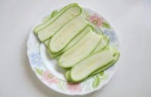 While the chicken is marinating, take care of the zucchini. Wash them and cut lengthwise into plates 2-3 mm thick. Sprinkle each plate wi...