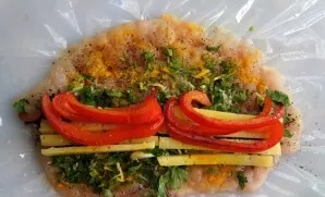 Salt the fillet, add black pepper and paprika to taste. Distribute greens with garlic. Put on paprika and cheese.