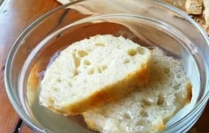 We put the bread in a deep plate and pour 1 glass of water. Soak for 10-12 minutes.