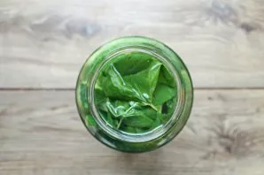 Pour the jars with cucumbers with hot water, cover and leave for 15 minutes.