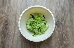 Wash, dry and tear the lettuce leaves with your hands and put them in a salad bowl.