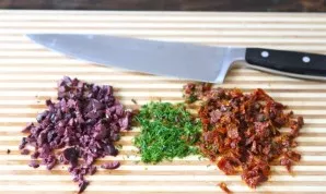 Finely chop the olives, dill and sun-dried tomatoes with a knife.