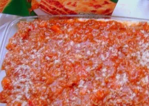 Put a layer of tomato sauce on top of the ricotta and sprinkle with grated cheese. Lay out the last layer of lasagna sheets and tomato sa...