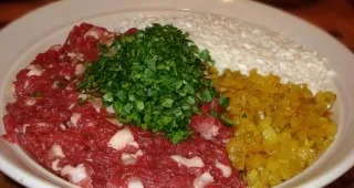 Lets prepare everything you need for the filling: an onion baked with garlic, meat, boiled rice and chopped herbs.