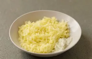 Peel the potatoes and onions, then grate. Squeeze out excess fluid.