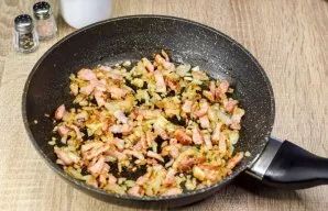 On the stove we heat the pan, put the bacon and onion, stirring we fry for 4-5 minutes. If necessary, add a little oil.