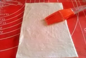 Preheat oven to 180 degrees. Sprinkle the work surface with flour. Roll out the dough with a rolling pin in one direction. Do not bite ha...