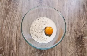 Pour vegetable oil into the pan and heat it on medium heat. Pour milk into a bowl, add egg, salt and pepper. Mix everything until smooth.