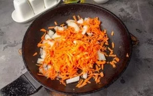 Finely chop the onion, grate the carrots. Put the vegetables in a pan with hot oil and fry for a couple of minutes.