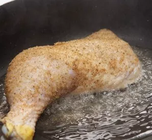 Heat the olive oil in a pan over medium heat. Place the chicken quarters in the heated oil.