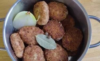 We put the cutlets in a saucepan, add bay leaf, half onion and pepper peas.