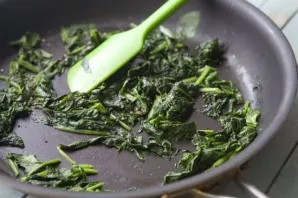 Rinse the spinach, chop it a little and put it in a pan. Fry a little with olive oil. Grate the cheese or cut into small cubes.