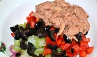 Transfer all prepared products to a bowl, put half a can of canned tuna (first drain the water and crush the fish with a fork).