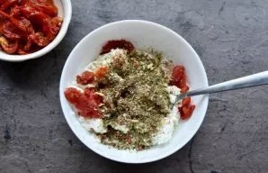 Add a pinch of salt, a mixture of herbs and chopped sun-dried tomatoes to the cottage cheese. Stir.