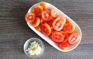 Cut the tomatoes into balls or slices. Peel and chop the garlic.