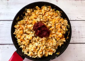 Add tomato paste to minced meat with vegetables, mix well and simmer for 15-20 minutes.