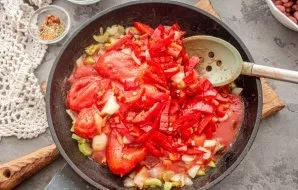 Add canned tomatoes to the vegetables in the pan.