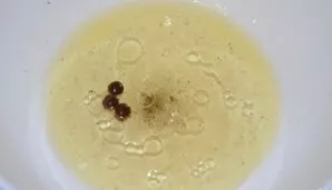 Preparing the marinade for fish. Pour hot water into a small bowl, add black and allspice, sugar, vinegar and vegetable oil. Stir.