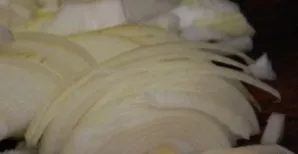 Clean the onion and cut into half rings.