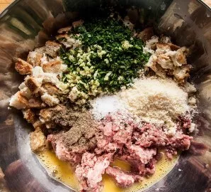 Place squeezed bread, egg, garlic, herbs, salt and pepper in a deep bowl of the minced meat. You can also put a little grated cheese. Sti...