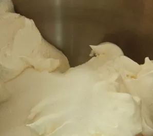 While whisking, gradually add warm milk to the mass.