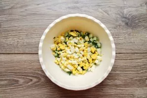 Cut the eggs into cubes and put them in a bowl with cucumbers.