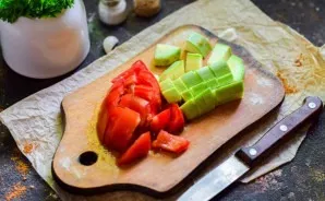 Cut zucchini and tomato into small cubes.