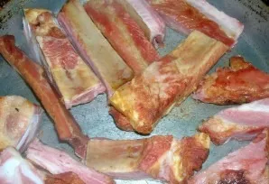 Fry the pork ribs in a dry frying pan and transfer to a saucepan.