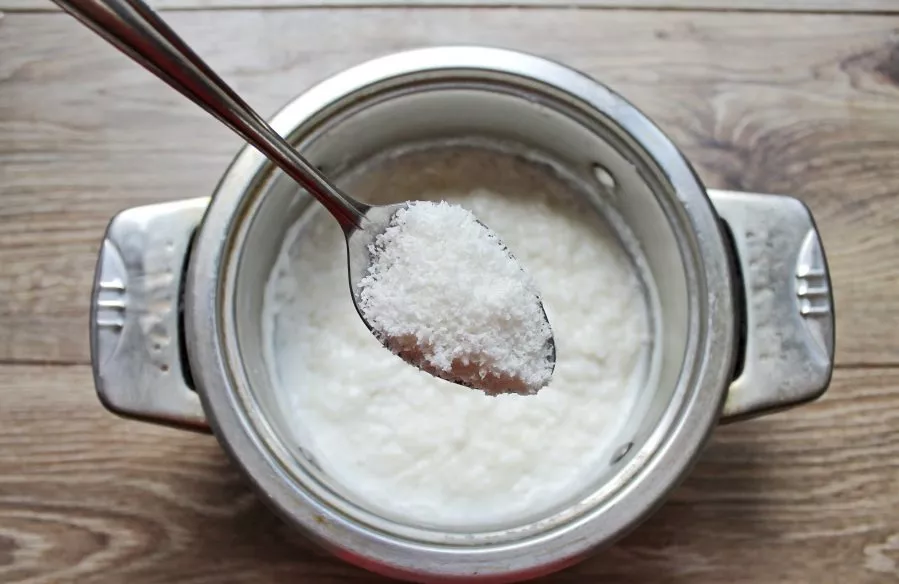 Add sugar and coconut flakes to the porridge. Mix everything and cook under the lid for another 5 minutes.