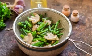Boil the mushrooms with beans for 7-8 minutes, then drain the water, let the vegetables cool.