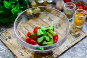 Cut the cucumber into small pieces and put it in a bowl with tomatoes.