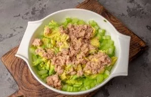 Drain the tuna juice or oil and put in bowls with salad.