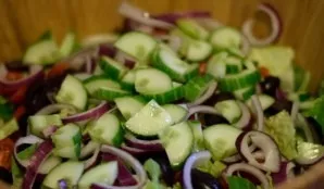Now cut the red onion into half rings. Add to the rest of the ingredients. We also send a cucumber cut into rings.