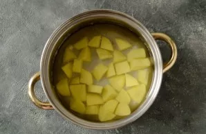 Pour water into the pot, put the shaved and diced potatoes. Salt, bring to a boil and cook for 10 minutes.