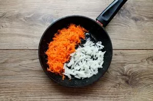 Peel and wash carrots and onions. Pour vegetable oil into the pan, add grated carrots and finely chopped onions.