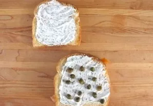 Place thin slices of pickled cucumbers, capers or green olives on the second slice of bread. Place the second slice of bread on top of th...