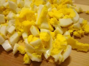 Cool the eggs and peel them. Cut into small cubes.