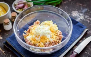 Peel the boiled chicken egg, grate on a fine grater and put in a bowl with tuna.