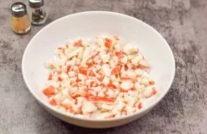 Finely chop the crab sticks and put them on a plate.