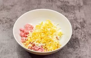 Cut the ham into small pieces and put on a plate. Also, grate the boiled eggs on a fine grater and put in a bowl.