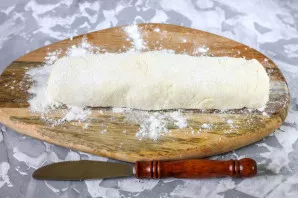 After sifting, add wheat flour. Leave a little flour to roll and fry the curds. Knead and form a sausage from the dough.