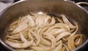 Return the pan to the heat and heat it, cut the onion into slices and put in a pan, fry for about 5-8 minutes.