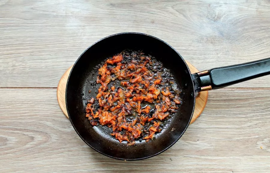 Pour vegetable oil into the pan, add finely chopped onions and grated carrots. Stir fry everything for 7 minutes. Add the roasted vegetab...