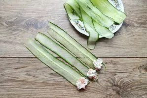 Lay out the strips of cucumber and put the filling with fish on one edge. Roll the stuffed slices into rolls and serve.