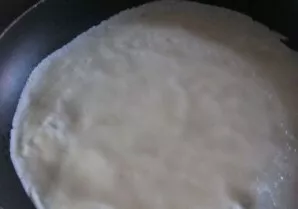 Heat a pan greased with vegetable oil over medium heat and start frying thin pancakes.