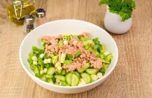 Add tuna and finely chopped onion letters to the salad. Season the salad with oil and lemon juice, add salt and pepper to taste.