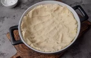 Divide the dough into a shape with a diameter of 20-22 cm, raising along the sides. Send the dough to bake in an oven preheated to 190-20...