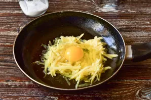 Beat the egg into the groove made in the potato.