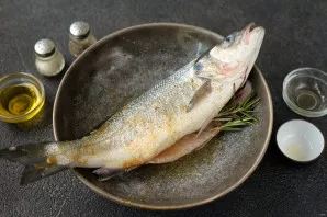 Rub the fish from the inside and outside with oil and spices , add rosemary to the belly.